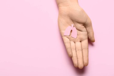 Pembe arka planda kağıt ciğerli bir kadın.