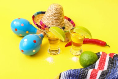 Sarı arka planda tekila, limon ve marakas.