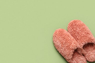 Yeşil arka planda bir çift yumuşak kırmızı terlik. Üst görünüm