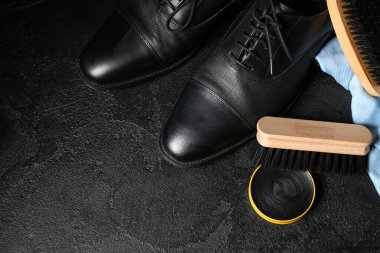 Siyah arka planda fırçalar, ayakkabılar, kumaşlar ve ayakkabı cilası