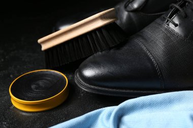 Siyah arka planda fırçalar, ayakkabılar, kumaşlar ve ayakkabı cilası