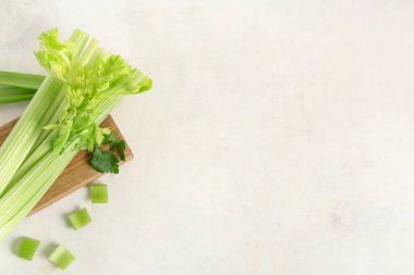 Beyaz zemin üzerinde taze yeşil kereviz demeti ile ahşap tahta tahta