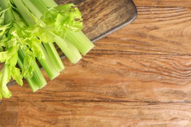 Ahşap zemin üzerinde taze yeşil kereviz olan tahta.