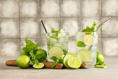 Gri masadaki limonlu ve naneli taze Mojito kokteyli.