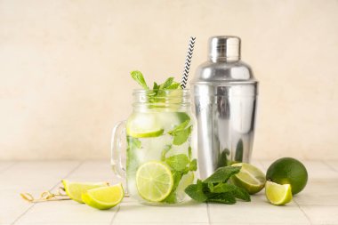 Mason kavanozu taze mojito kokteyli, limonlu ve sallanan beyaz fayanslı.