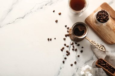 Bir fincan kahve ve sıcak kahve. Işık masasında.