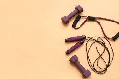 Genişletici, dambıl ve bej arka planda atlama halatı