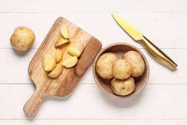 Beyaz ahşap arka planda çiğ patatesli tabak ve yemek.
