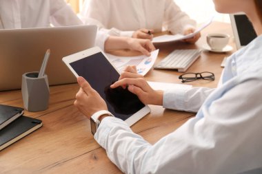 Ofisteki toplantı sırasında tablet ve dizüstü bilgisayarlarla çalışan iş ekibi, yakın çekim