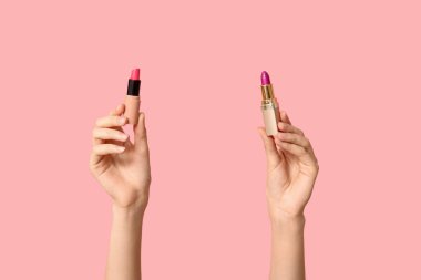 Pembe arka planda farklı ruj izleri olan kadın elleri.