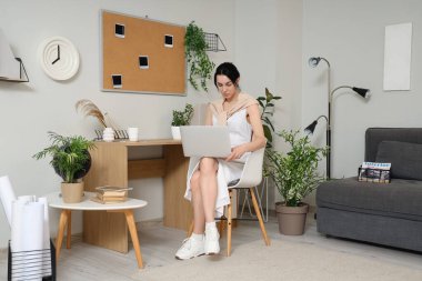 Bilgisayarla çalışan genç bir kadın.