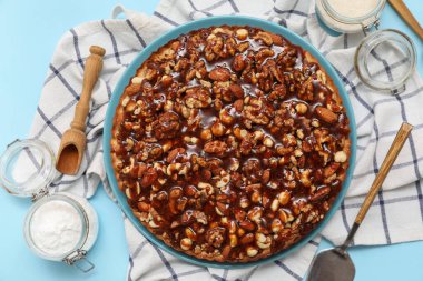 Farklı fındıklı tatlı tart tabağı ve mavi arka planda malzemeler