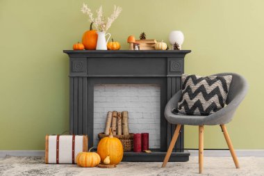 Siyah şöminesi, rahat koltuğu ve balkabağı olan rahat bir oturma odası. Sonbahar konsepti