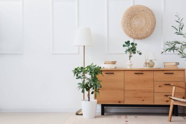 Odanın içinde ahşap klozet, lambalar ve bitkiler var.