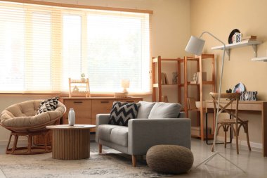 Koltuğu, koltuğu ve raf ünitesi olan şık bir oturma odası.