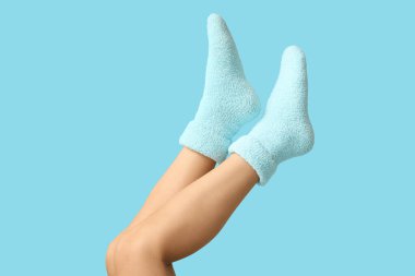 Arka planda sıcak mavi çoraplı genç kadın bacakları