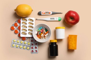 Renkli arka planda farklı ilaçlar, meyveler ve termometreler içeren kompozisyon. Dokunulmazlık artırıcı kavram