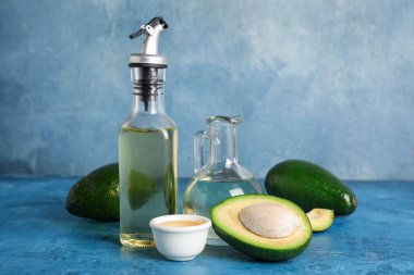 Olgun avokado, şişe ve yağ sürahisi