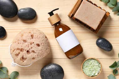Kozmetik ürünleri, banyo süngeri ve ahşap arka planda spa taşlarıyla kompozisyon