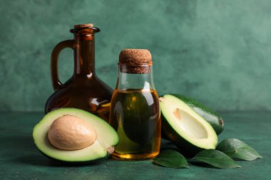 Yeşil arka planda bir şişe avokado yağı.