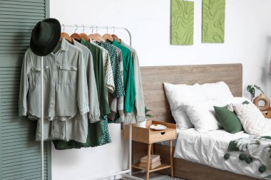 Modern yatak odasının içinde giysi askılığı ve katlama perdesi var.