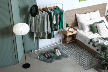 Elbise askılığı ve katlama perdesi olan şık bir yatak odası.