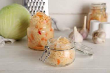 Masada beyaz arka planda duran lezzetli lahana turşusu kavanozları. Yakın çekim.