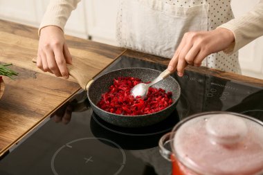 Mutfakta sebze kızartan genç bir kadın, yakın plan.