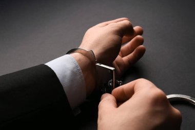İş adamı elleri kelepçeleri siyah arkaplanda açıyor