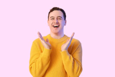 Renkli arka planda yakışıklı, mutlu genç bir adam.