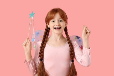 Hoş kızıl saçlı peri pembe arka plandaki bir şeyi işaret ediyor.