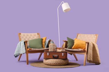 Klasik valizli şık koltuklar, kitaplar ve arkaplanda standart lamba.