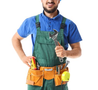 İngiliz anahtarı ve profesyonel aletleri olan mutlu erkek inşaat işçisi beyaz arka planda izole edilmiş, yakın plan