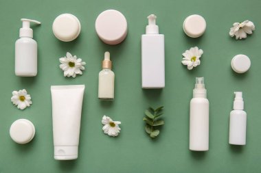 Farklı kozmetik ürünleri ve yeşil arka planda güzel çiçekler.