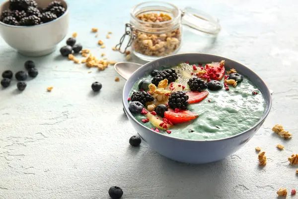 Bir kase lezzetli spirulina smoothie ve hafif grunge arka planda böğürtlenler, yakın plan