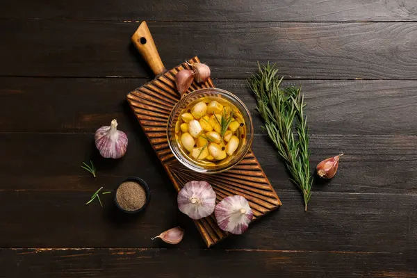 Cam kase taze sarımsak yağı biberiye ve ahşap zemin üzerinde biber.