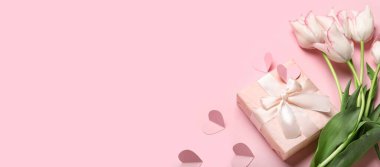 Güzel lale çiçekleri, hediye ve kalpler pembe arka planda metin için yer var. 