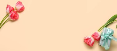 Güzel laleler ve bej arkaplanda hediye. Metin ve üst görünüm için yer var.