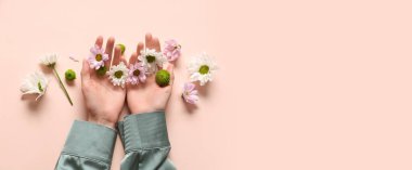 Pembe zemin üzerinde kadın elleri ve çiçekler metin için boşluk, üst görünüm