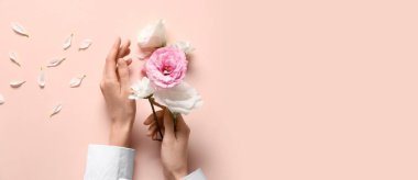 Pembe zemin üzerinde kadın elleri ve çiçekler metin için boşluk, üst görünüm