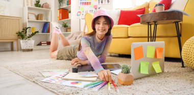 Ofiste yerde keçeli kalemlerle çalışan güzel bir grafik tasarımcısı.