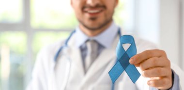 Klinikte mavi kurdeleli erkek ürolog, yakın plan. Prostat kanseri farkındalığı