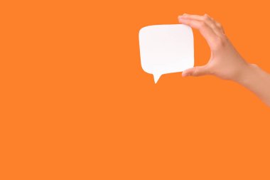 Turuncu arka planda boş konuşma balonu tutan kadın