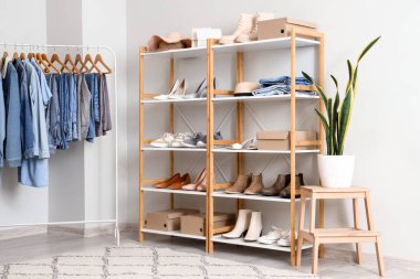 Butikte farklı şık ayakkabıları, askısı ve kıyafetleri olan raf ünitesi.