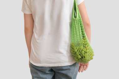 Taze üzümlü kadın ağ torbasında, arka planda.