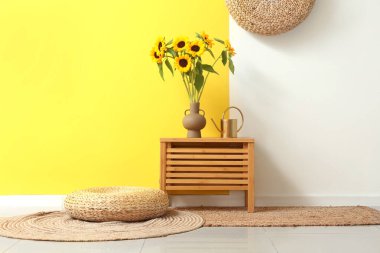 Çekmecede ayçiçekli vazo ve sulama kutusu var.