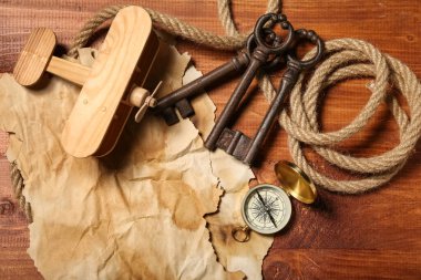 Seyahat ekipmanlı uçak oyuncağı ve kahverengi ahşap arka planda anahtarlar