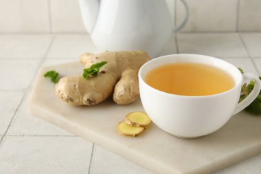 Beyaz fayanslı, zencefilli çay ve nane şekerli tahta.