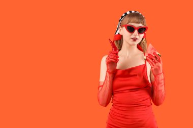 Kırmızı arka planda taze karpuz ve kırmızı biberli genç bir kadın.