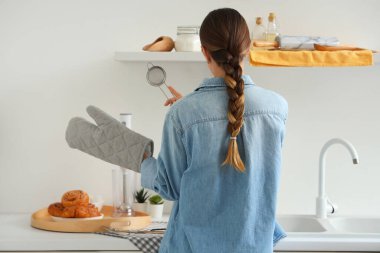 Fırın eldivenli kadın taze çörekler ve fırın için mutfak gereçleri.